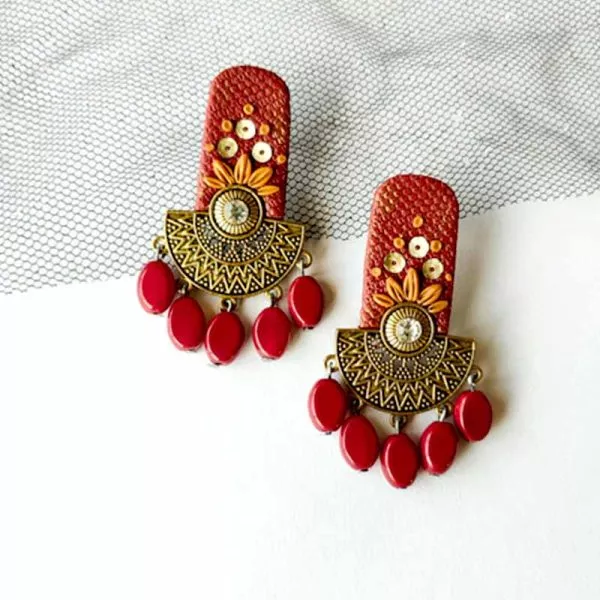 Bask in the glory with fusion earrings, a mix of modern design with ethnic style. It's a dark shade of red and golden. Adorned with alluring charm and to finish off, beads are rounding out the style.