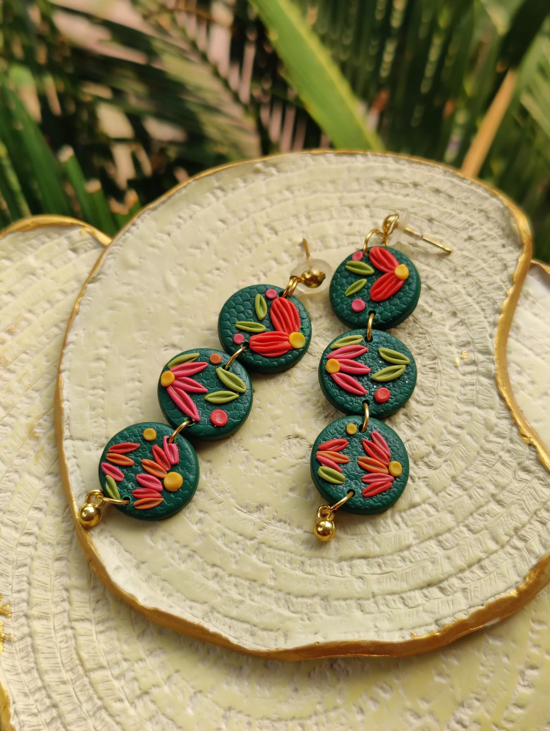 3-Tier Small Embellished Circles in Green and Orange Round earrings design is a fun way to add color to your look. 3 small rounds with a dark green base, embellished with multi-colored intricate style to work its magic on you.