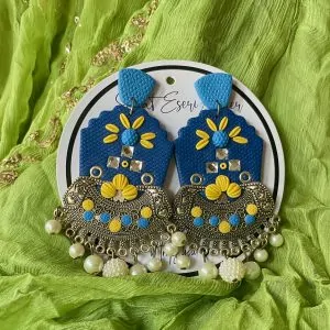 A vibrant and intricate blend of traditional and contemporary design elements, our antique silver crescent-shaped earring features a textured orange base with a floral embellishment made of colorful beads and sequins in pink, yellow, green, and white.