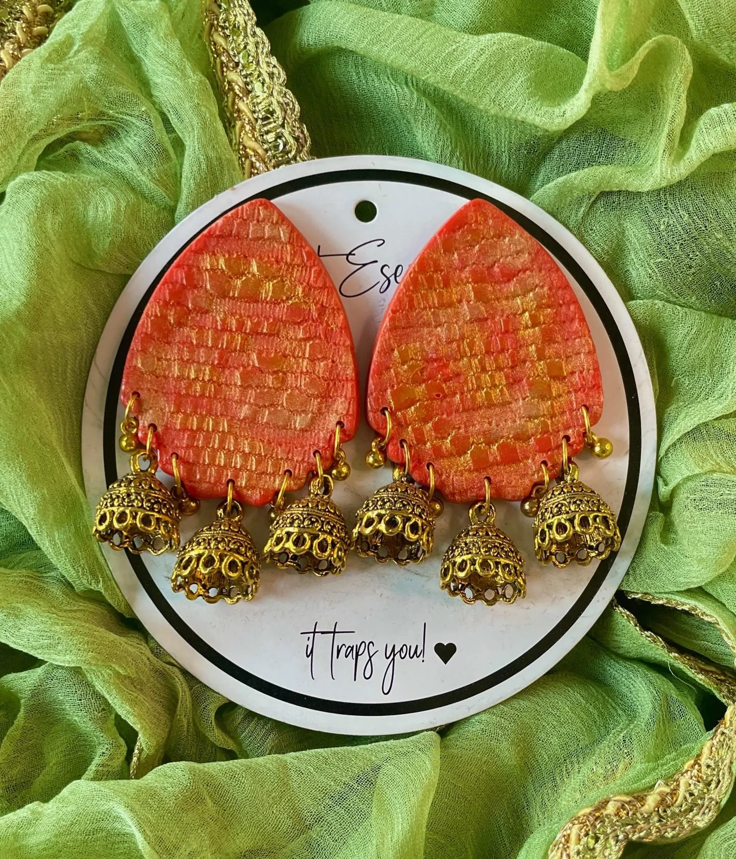This is our big statement earrings that are beautifully handcrafted with a vibrant and textured orange-red teardrop-shaped base.