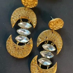 A pair of handmade brass-look drop earrings made from polymer clay. Lightweight, gold-toned, with a unique geometric design, perfect for any occasion.