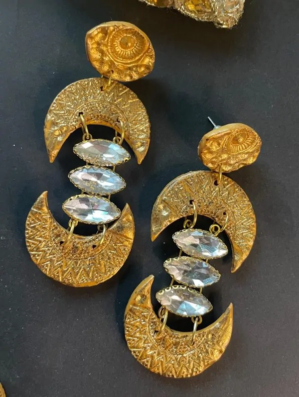 A pair of handmade brass-look drop earrings made from polymer clay. Lightweight, gold-toned, with a unique geometric design, perfect for any occasion.