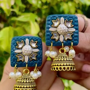 Deep teal square textured earrings with silver-toned floral work and Jhumka bell drops.