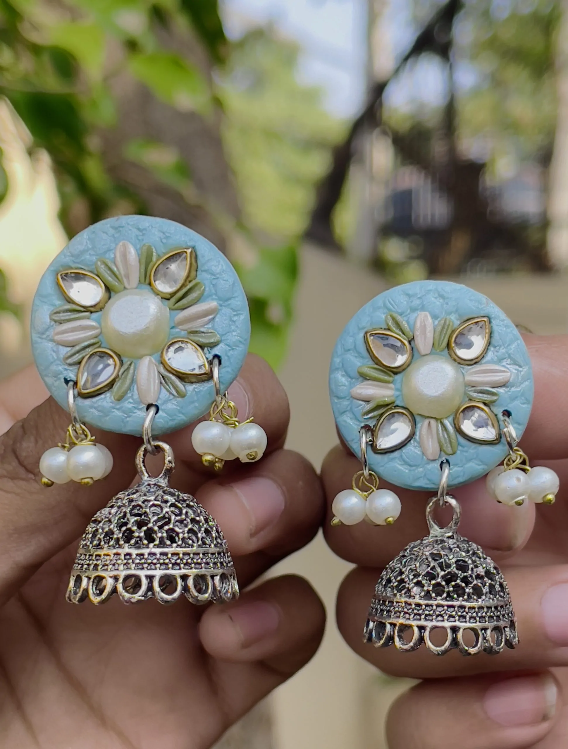 sky blue round textured earrings with gold Jhumka bells.