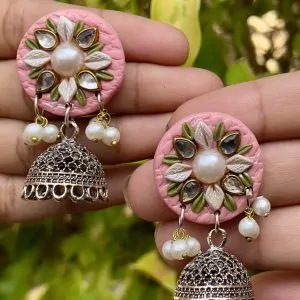 Pink round textured earrings with gold Jhumka bells.