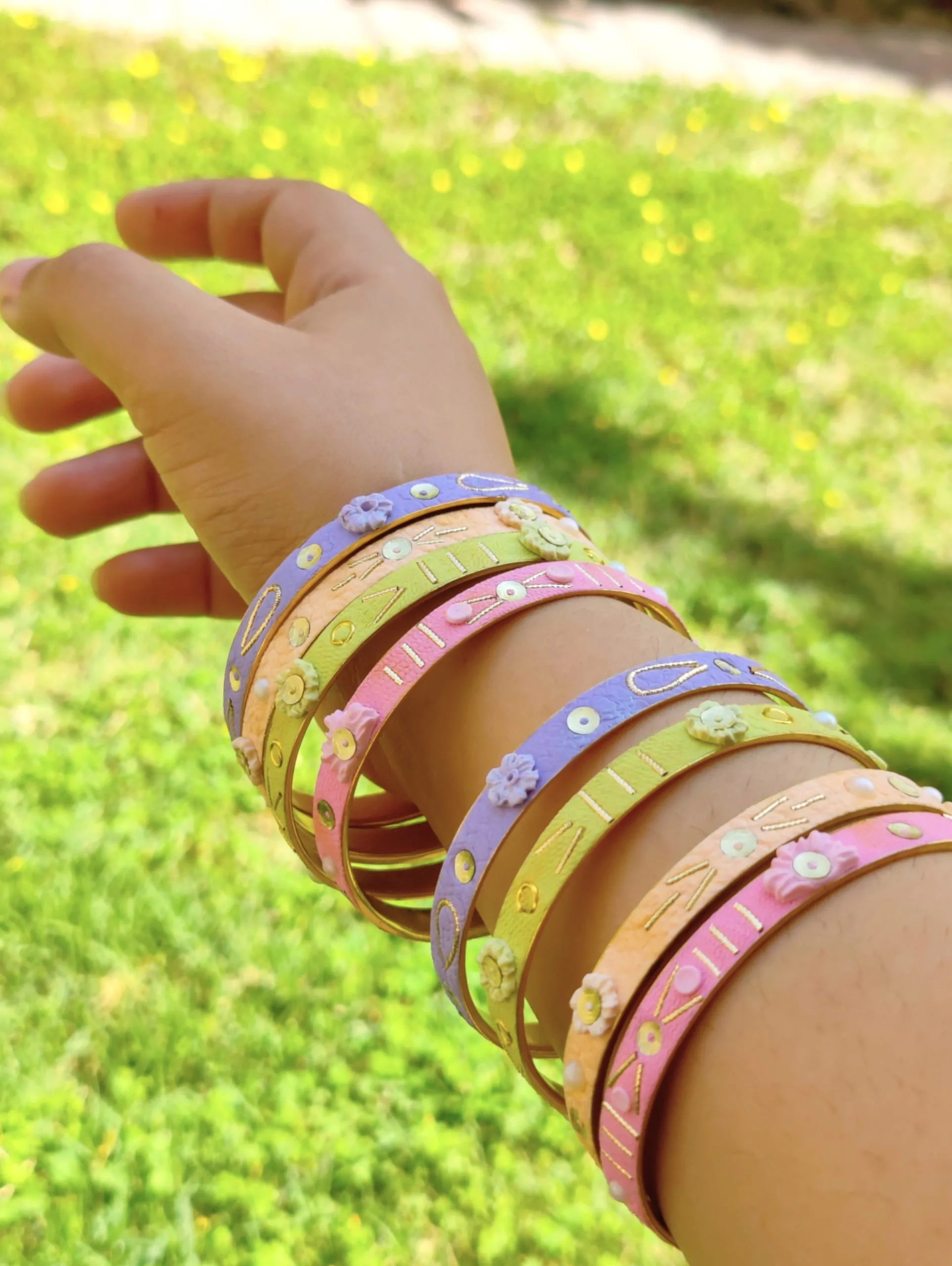 IMG20240314140452 Artisan stack of pastel lilac, mint, and pink textured bangles with hand-sculpted white clay flowers, gold embroidery, and pearl accents