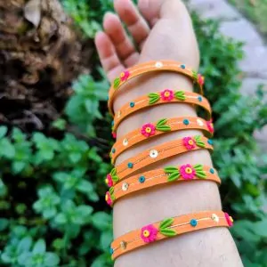 Handcrafted zesty orange textured bangles with 3D neon pink clay flowers and gold sequin details