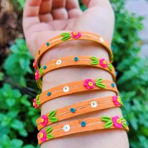 Handcrafted zesty orange textured bangles with 3D neon pink clay flowers and gold sequin details