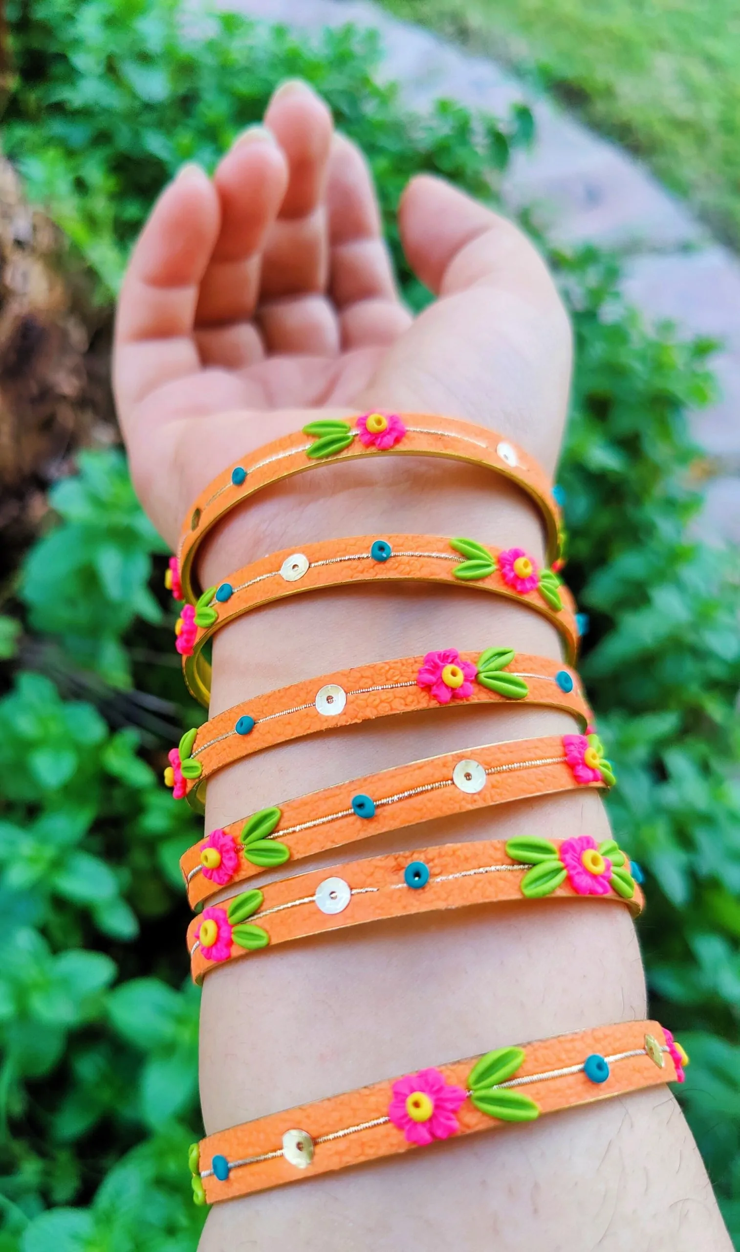Handcrafted zesty orange textured bangles with 3D neon pink clay flowers and gold sequin details