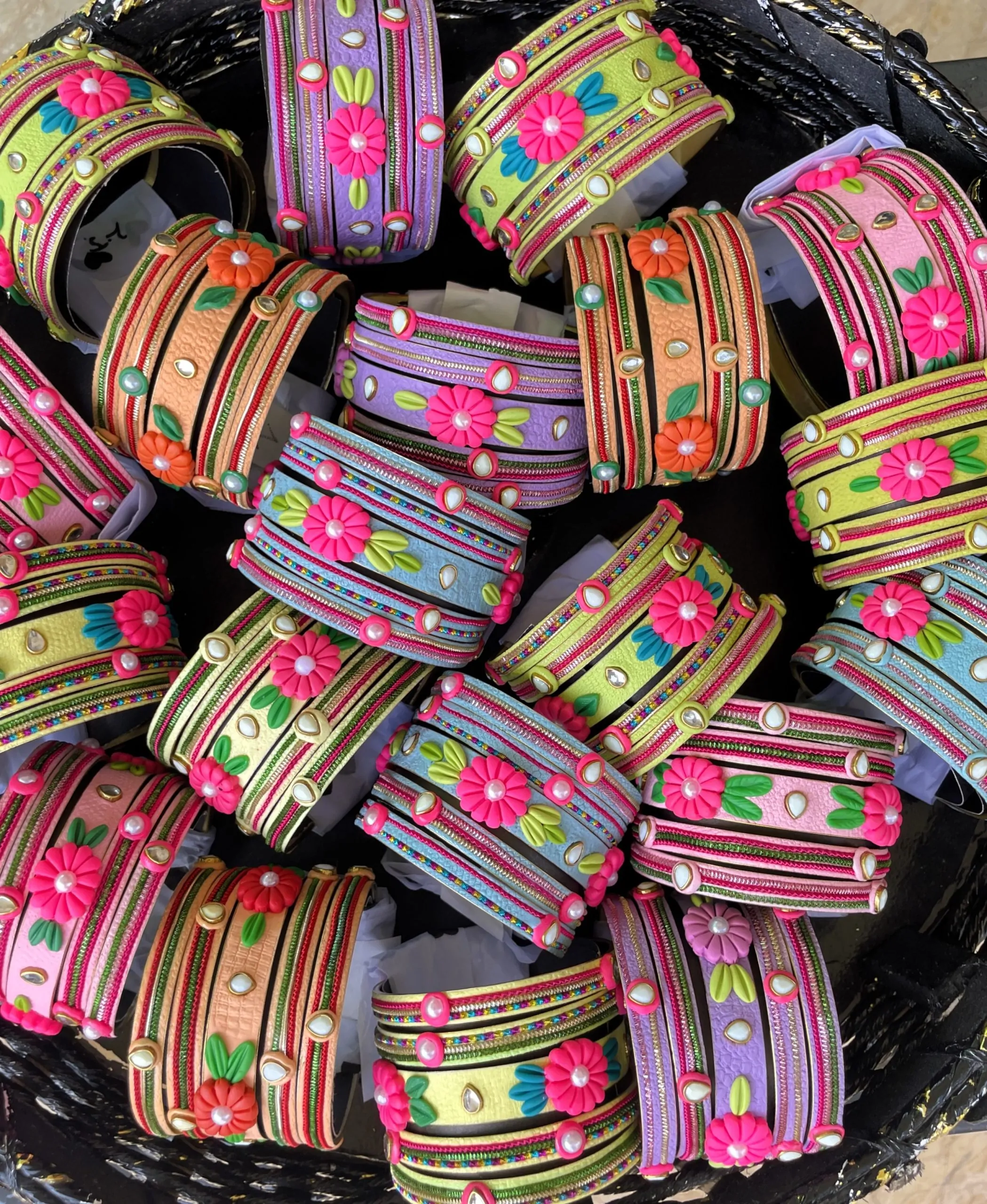 IMG_5045 Artisan stack of lemon yellow textured bangles featuring a large 3D fuchsia clay flower, rainbow metallic embroidery, and crystal accents.