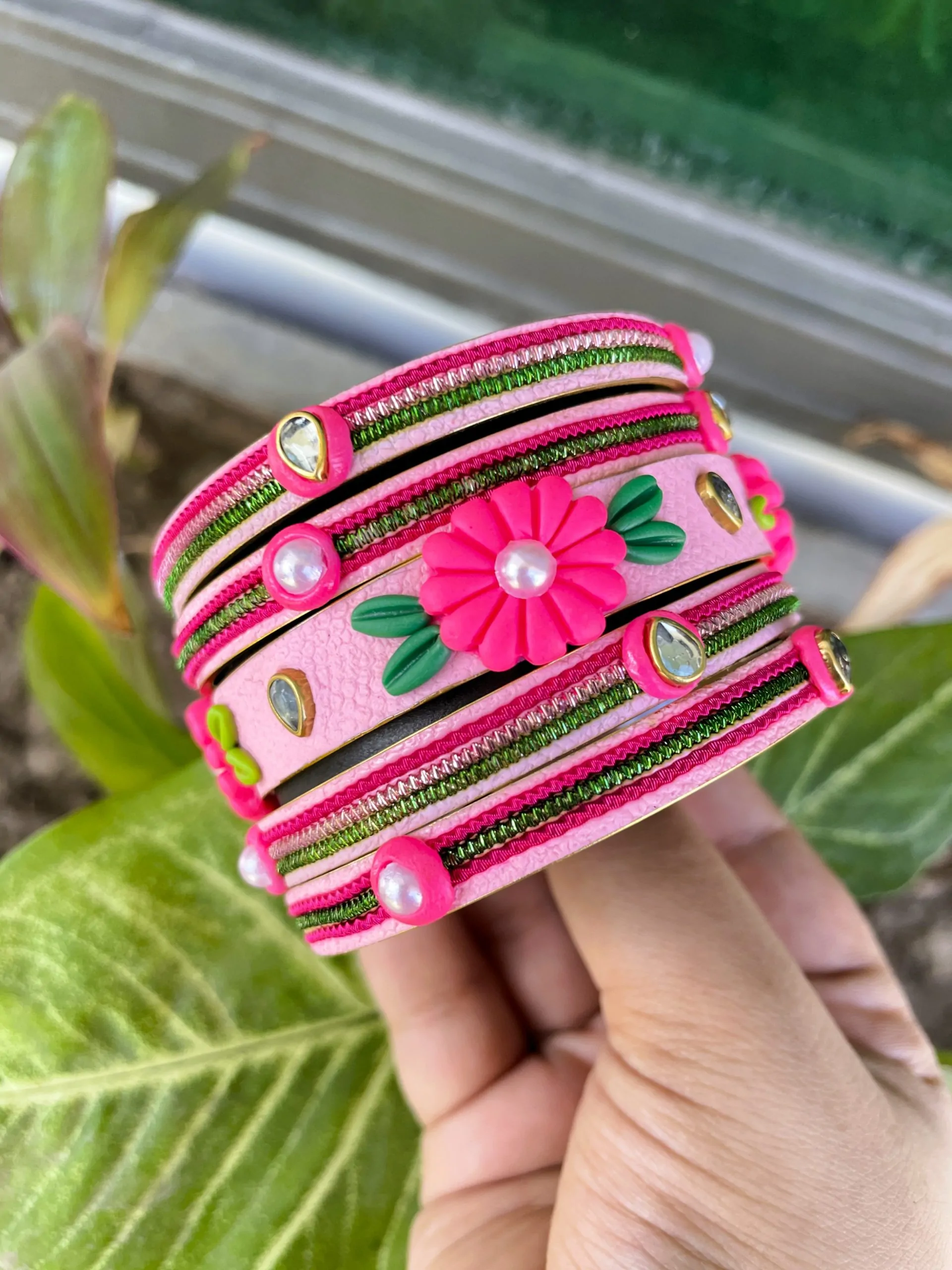 IMG_5064 Artisan stack of fuchsia pink textured bangles featuring a large 3D clay flower, green metallic embroidery, and kundan crystal accents.