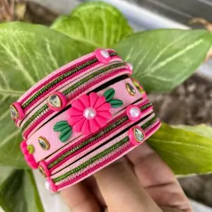 Artisan stack of fuchsia pink textured bangles featuring a large 3D clay flower, green metallic embroidery, and kundan crystal accents.