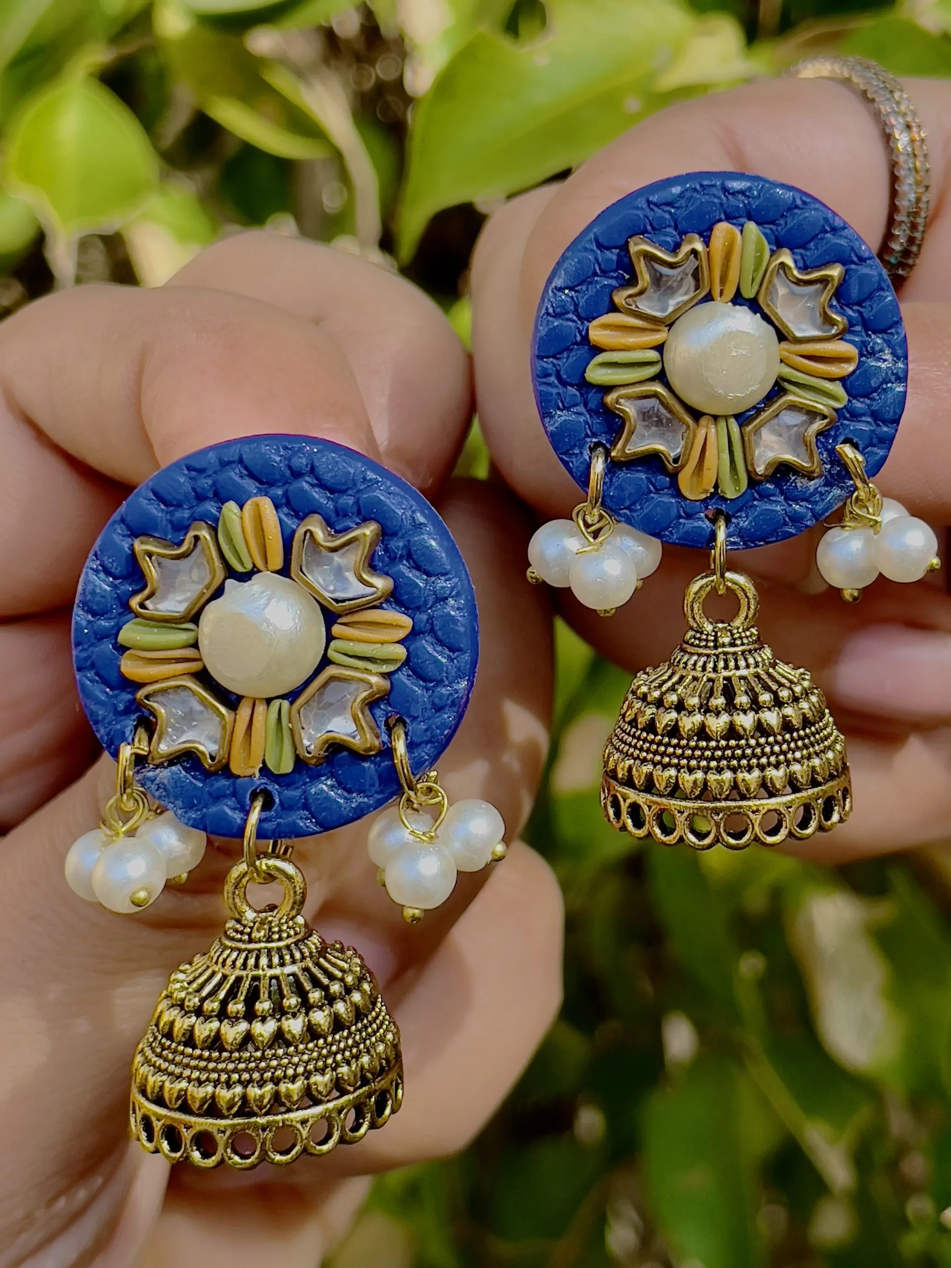 Royal blue round textured earrings with gold Jhumka bells and star mirrors.