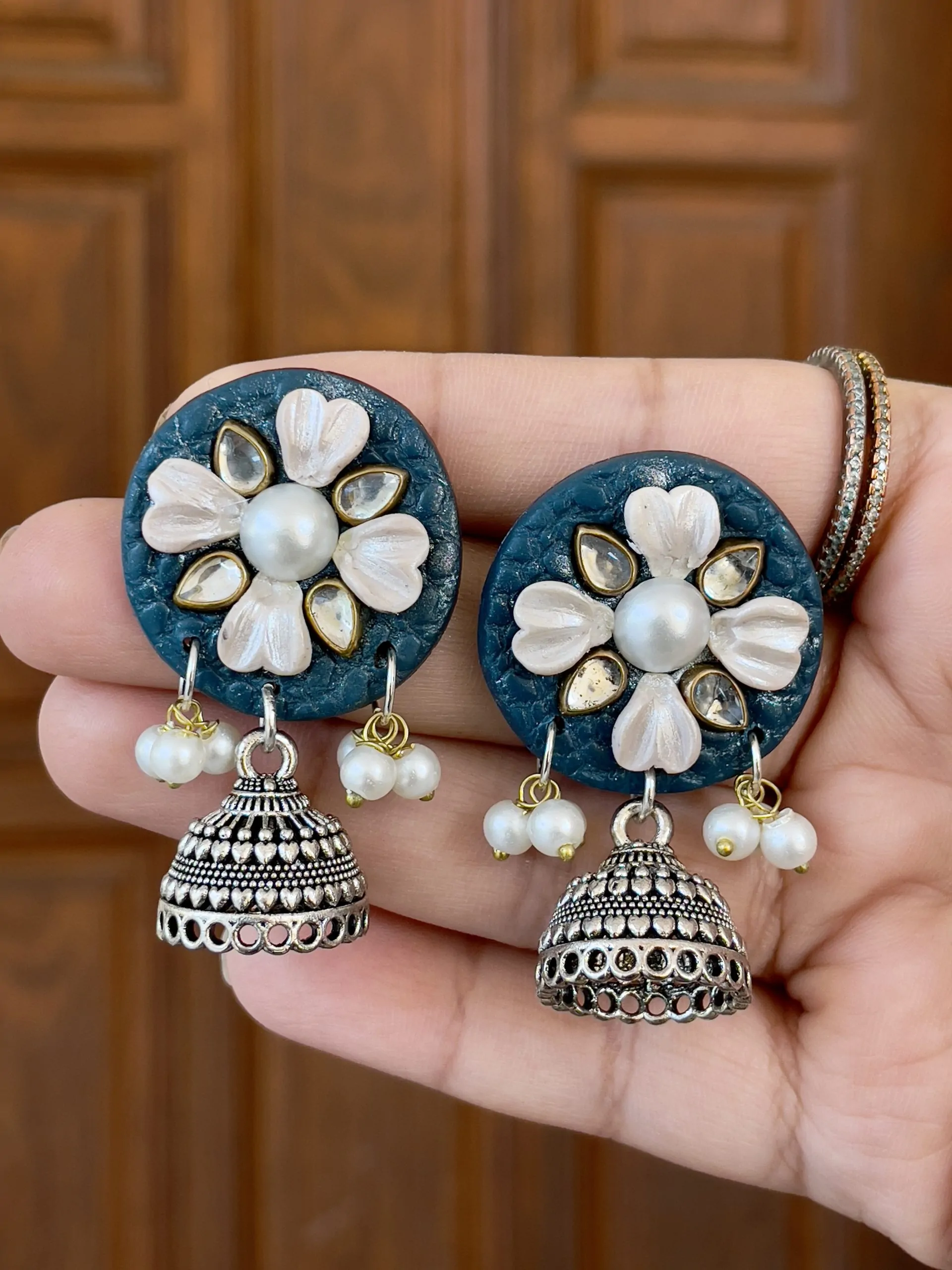 Teal blue round textured earrings with silver-toned floral accents
