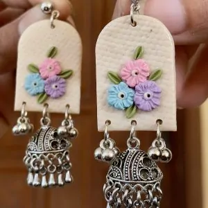 Arched cream earrings with sky blue, pink, and lavender flowers and silver Ghungroo Jhumkas
