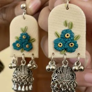 Arched textured earrings with teal blue floral cluster and heavy silver Ghungroo bell drops.
