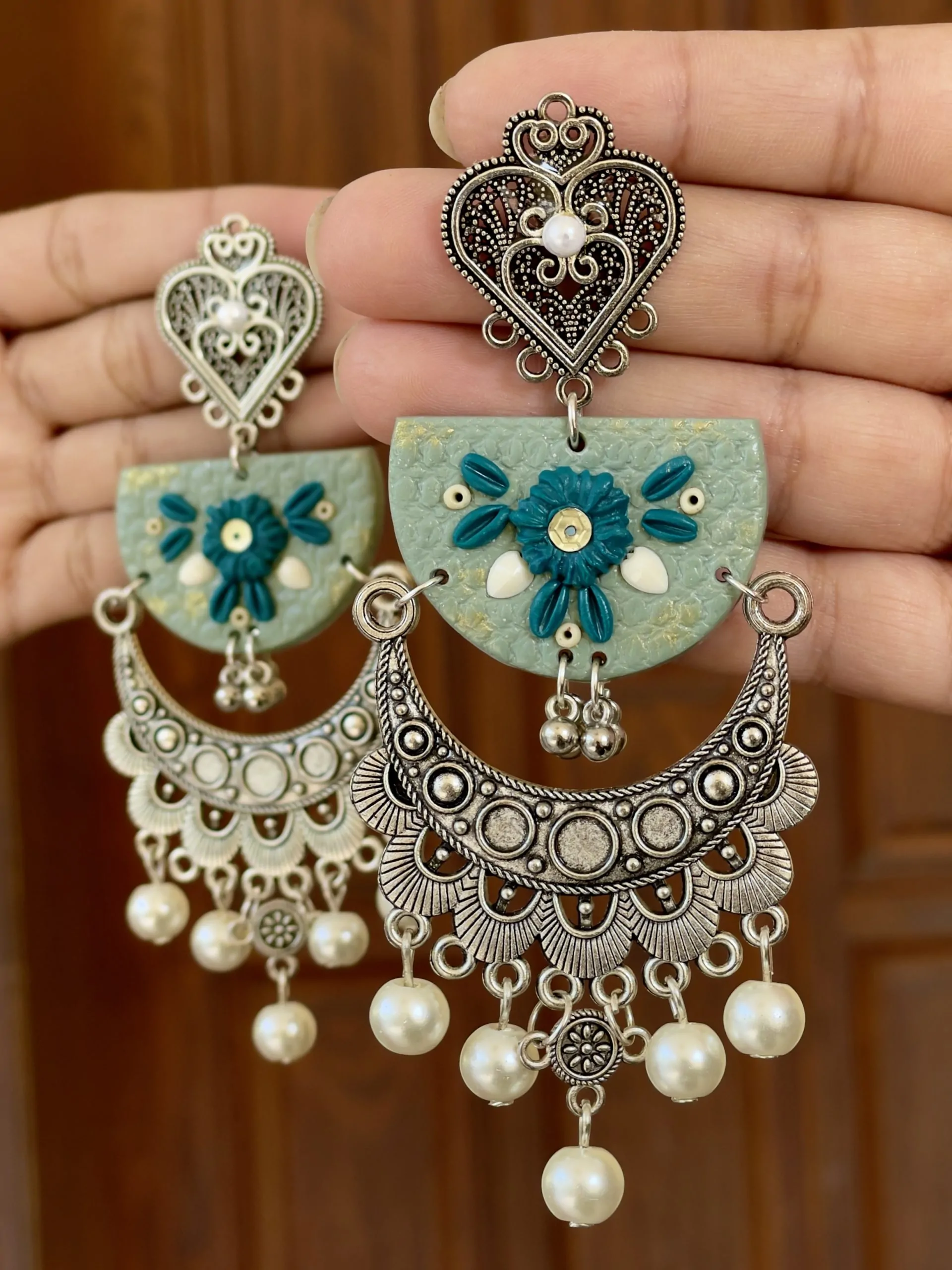 Ornate sage green floral earrings with heart-shaped silver studs and cascading pearls