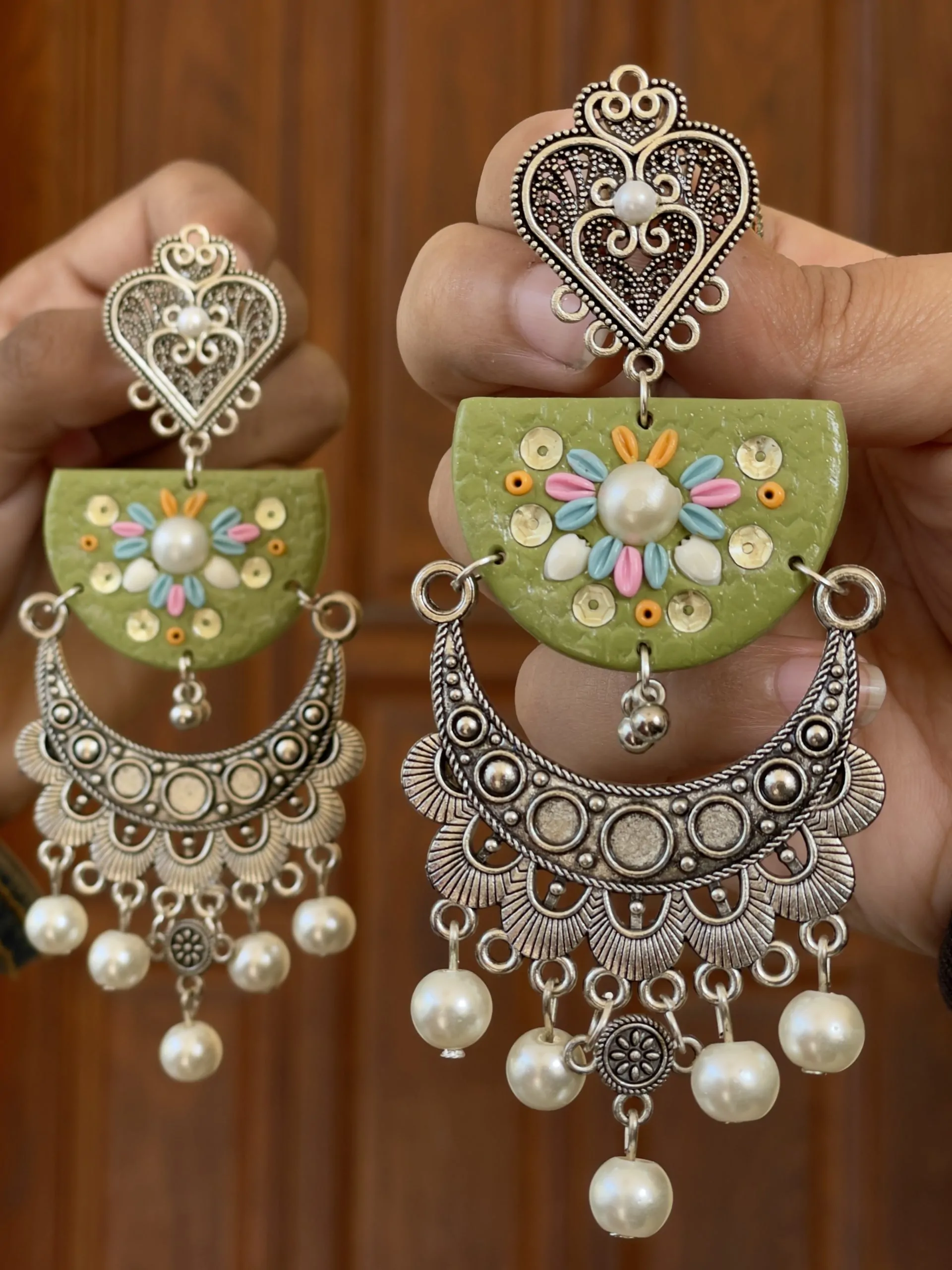 Boho-style olive green earrings featuring multicolor floral blooms and intricate silver-toned metalwork