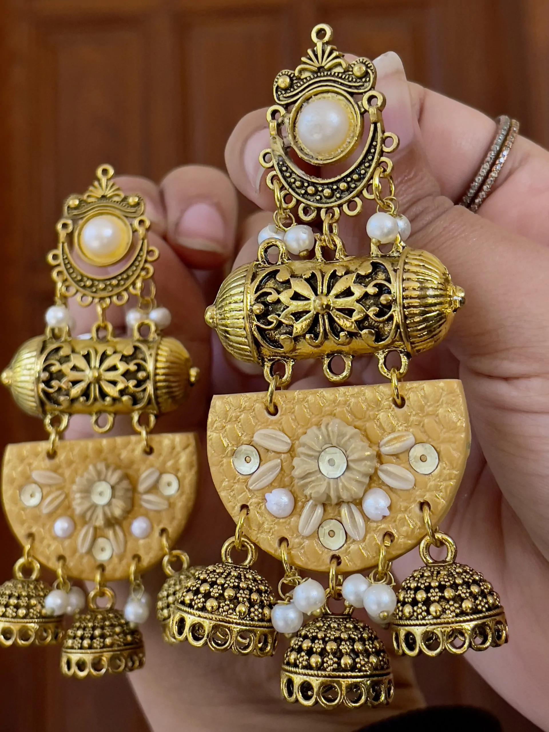 Ochre yellow textured chandelier earrings with cream floral details and gold metalwork.