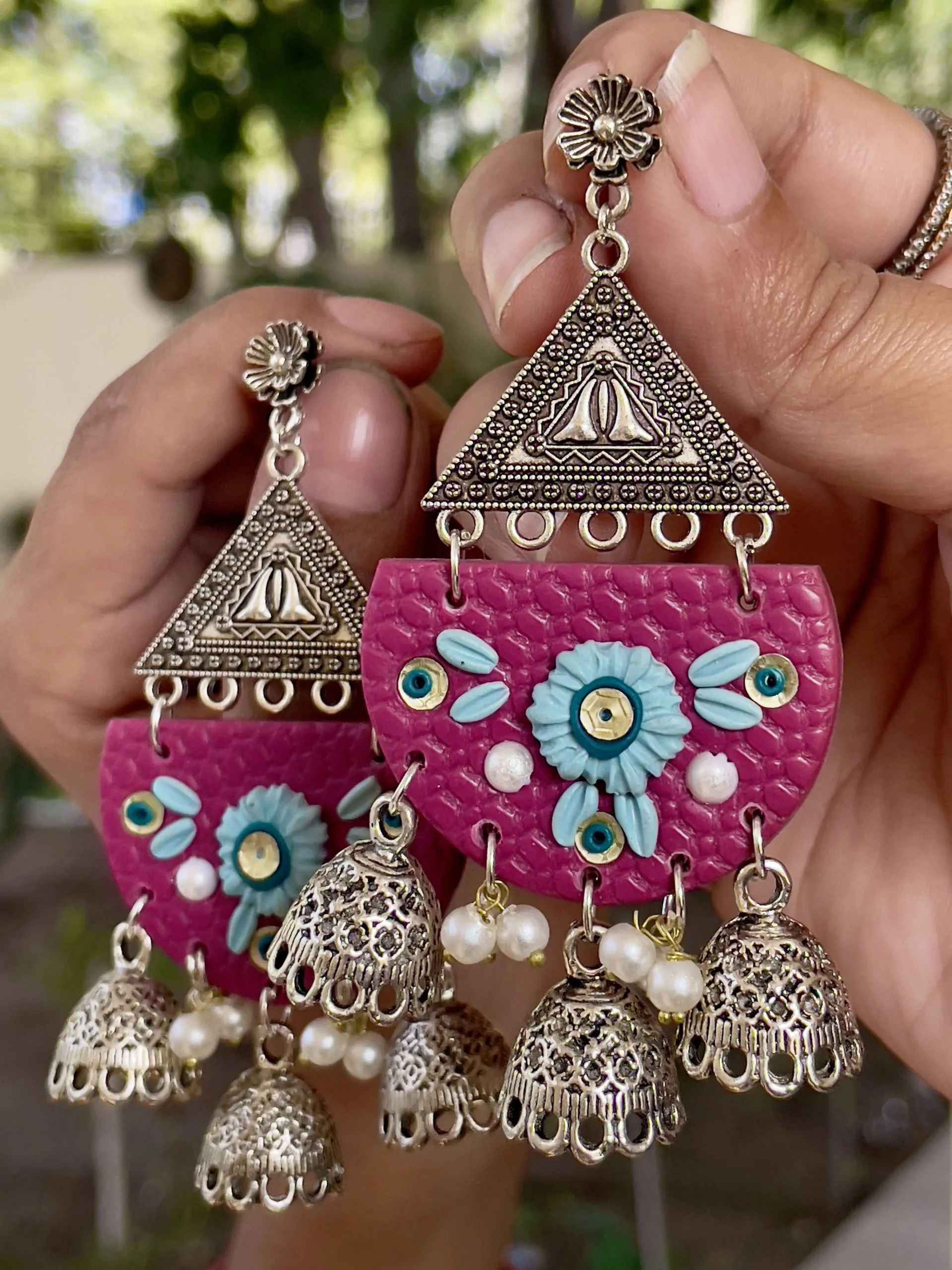 Maroon half-moon chandelier earrings with silver filigree and five Jhumka bell drops